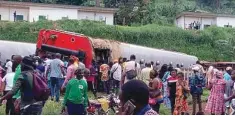  ??  ?? People gather to watch a train that derailed and overturned while travelling between Cameroon’s capital Yaounde and the port city of Douala.