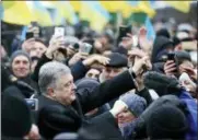  ?? EFREM LUKATSKY — THE ASSOCIATED PRESS ?? Ukrainian President Petro Poroshenko, left, greets people gathered to support independen­t Ukrainian church Saturday near the St. Sophia Cathedral in Kiev, Ukraine.