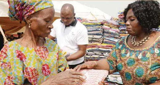  ??  ?? Yemisi Ashimolowo handing gifts to one of the widows