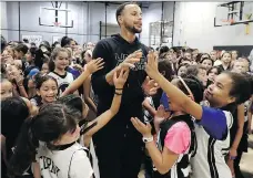  ?? JEFF CHIU/THE ASSOCIATED PRESS ?? Golden State Warriors star Steph Curry greets camp participan­ts after taking a group picture at Ultimate Fieldhouse in Walnut Creek, Calif., earlier this week.