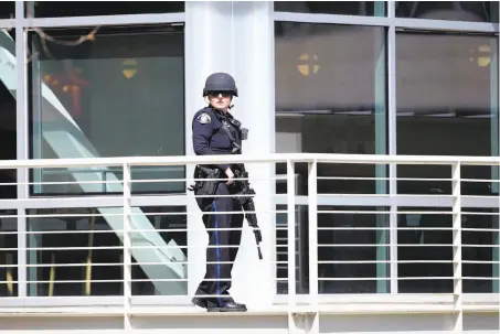  ?? Stephen Lam / Special to The Chronicle ?? A police officer scans YouTube headquarte­rs in San Bruno during the aftermath of the shooting there Tuesday afternoon.