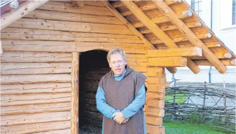  ?? ARCHIVFOTO: CORINNA WOLBER ?? Bert Geurten steht in der Mönchskutt­e vor einem Holzhaus, das der Campus Galli in St. Gallen als Geschenk erhalten hat.