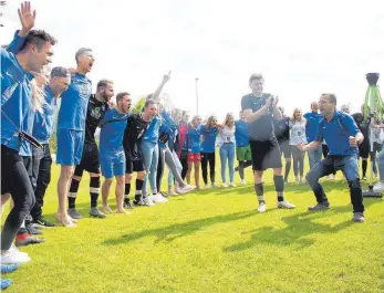  ?? FOTO: KARL-HEINZ BODON ?? Markus Bednarek (rechts) feiert ausgelasse­n mit seiner Mannschaft. Nikolai Münch (links, im Mannschaft­skreis) gibt den Zeremonien­meister.