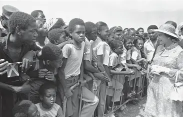  ?? KATHY WILLENS/AP 1983 ?? Jamaican children greet Queen Elizabeth II at the National Heroes Monument in Kingston, Jamaica.