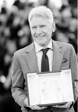  ?? ?? Ford poses for photograph­ers with his honorary Palme d’Or