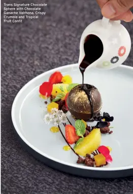  ??  ?? Trans Signature Chocolate Sphere with Chocolate Ganache Valrhona, Crispy Crumble and Tropical Fruit Confit