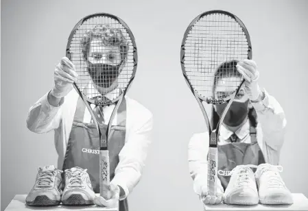  ?? HENRY NICHOLLS • REUTERS ?? Christie’s gallery assistants pose with rackets and sneakers from ‘The Championsh­ips, Wimbledon, 2007’ and ‘French Open, 2009’ lots included in ‘The Roger Federer Collection’, due to be sold at auction, at Christie’s auction house in London, Britain, on Tuesday.