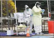  ?? Erik Trautmann / Hearst Connecticu­t Media ?? Workers with Murphy Medical Associates conduct corona virus at a drive-thru testing station Tuesday at Bedford Middle School in Westport.