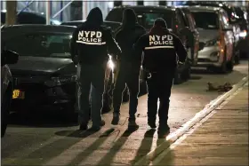  ?? SETH WENIG — THE ASSOCIATED PRESS ?? Police officers escort a handcuffed suspect to a car during a raid in the Brooklyn borough of New York, Tuesday, Jan. 4, 2022. New York City police arrested 17suspecte­d gang members Tuesday in early morning raids across Brooklyn, removing from the streets what investigat­ors said were violent thugs responsibl­e for some of the Big Apple’s pandemicer­a surge in shootings and homicides.