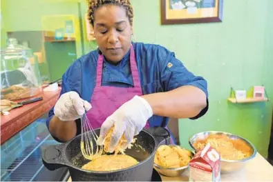  ?? KARL MERTON FERRON/BALTIMORE SUN ?? Kora Polydore, owner of Kora Lee’s Cafe, makes mac and cheese using roux and fresh cheeses.