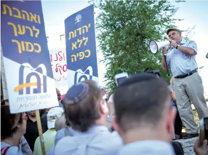  ?? (Hadas Parush/Flash90) ?? THEN-JEWISH AGENCY CHAIRMAN Natan Sharansky speaks at a protest held outside the Chief Rabbinate in Jerusalem, in 2016. The signs read ‘Love your neighbor as yourself’ and ‘Judaism without coercion.’