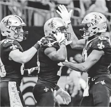  ??  ?? Saints receiver Michael Thomas (13) pulled out a cellphone to celebrate his touchdown with teammates Austin Carr (80) and Tre’Quan Smith. DERICK E. HINGLE/USA TODAY SPORTS