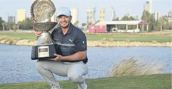  ?? ?? ↑ Ewen Ferguson shows off the trophy after landing his maiden DP World Tour triumph in the Commercial Bank Qatar Masters at Doha Golf Club