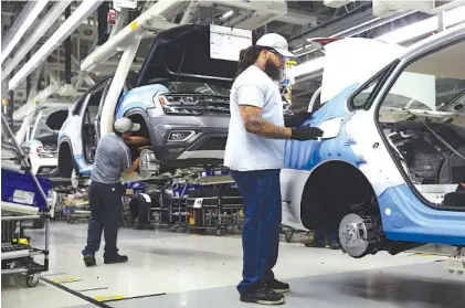  ?? STAFF FILE PHOTO BY ERIN O. SMITH ?? Employees work on vehicles moving down the assembly line in August at the Volkswagen plant in Chattanoog­a.