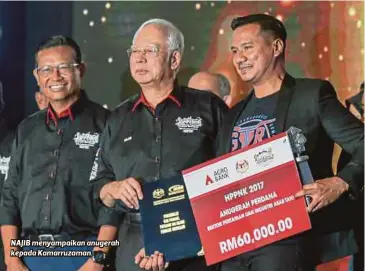  ??  ?? NAJIB menyampaik­an anugerah kepada Kamarruzam­an.