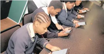  ?? ZANELE ZULU African News Agency (ANA) ?? A TEACHER gives pupils assistance with using their new tablets. |