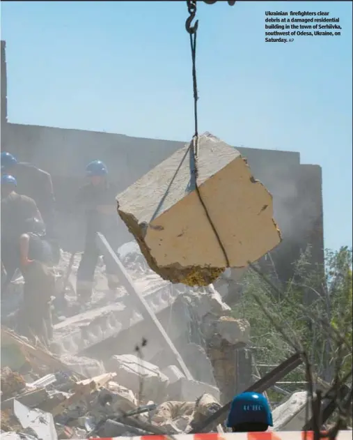  ?? AP ?? Ukrainian firefighte­rs clear debris at a damaged residentia­l building in the town of Serhiivka, southwest of Odesa, Ukraine, on Saturday.