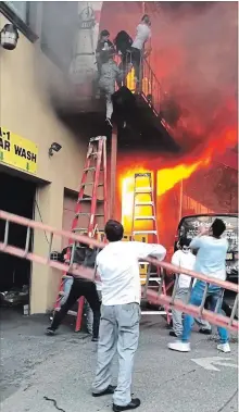  ?? ILKER KESIKTAS
THE ASSOCIATED PRESS ?? Girls flee a second-story dance studio onto a balcony as a fire engulfs their building in Edgewater, N.J. About 15 girls were treated for minor injuries, mayor Michel Joseph McPartland said. “I had trouble sleeping last night. It was crazy,” said Ilker Kesiktas, who shot the photo.