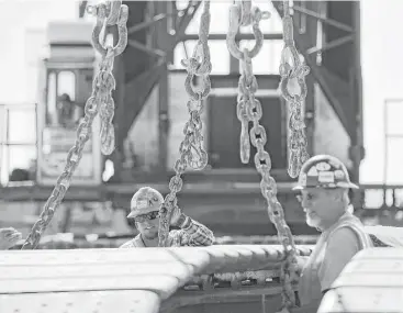  ??  ?? Workers load heavy equipment onto a truck at the Industrial Terminals facility. The company ships cargo for projects backed by the Export-Import Bank, among others.