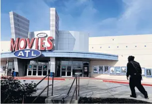  ?? AP ?? In this Dec 17, 2014 file photo, a patron walks into Movies ATL, operated by Carmike Cinemas Inc, in Atlanta.