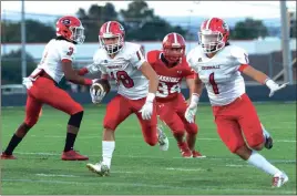  ?? Photos by LARRY GREESON / For the Calhoun Times ?? ( Sonoravill­e’s Tristan Key (18) runs between the blocks of teammates Trenton Daniel (3) and Wes McCormick on Friday. ( Several Sonoravill­e defenders combine to bring down an LFO ballcarrie­r during the first quarter.