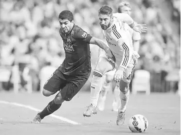  ??  ?? Barcelona’s Uruguayan forward Luis Suarez vies with Real Madrid’s defender Sergio Ramos during the Spanish league ‘Clasico’ between Real Madrid and Barcelona at the Santiago Bernabeu stadium in Madrid, in this October 2014 file photo. — AFP photo