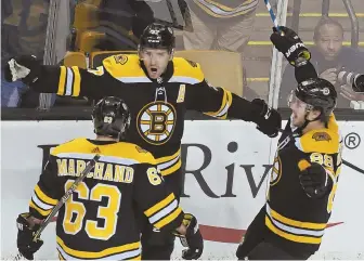  ?? STAFF PHOTO BY JOHN WILCOX ?? LETHAL LINEMATES: Bruins center Patrice Bergeron (center) celebrates his goahead goal with wingers Brad Marchand (63) and David Pastrnak in the third period of Saturday’s win over the Red Wings at the Garden.