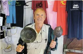  ?? Pictures: SUE MACLENNAN ?? COOL STUFF: Curator Alan Pike shows off some of the supercool stuff that will be on sale at the Bathurst Agricultur­al Museum’s stand at the Bathurst Agricultur­al Show, from March 22-24. He’s holding up handforged skillet and ladle, and behind him is an array of clothing, mugs and other memorabili­a.