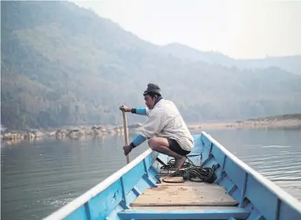  ?? REUTERS ?? In this file photo from February, a villager steers a boat where the future site of the Luang Prabang dam will be on the Mekong River in Laos. The Thai government and corporatio­ns are among the most vociferous proponents of dam projects in the country.