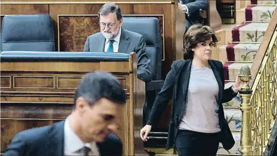  ?? ÓSCAR DEL POZO / AFP ?? La vicepresid­enta Soraya Sáenz de Santamaria mira de reojo a Sánchez al pasar junto a Rajoy, sentado en su escaño