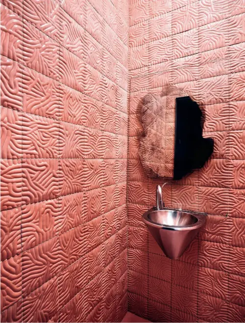  ??  ?? En el baño, tapizado con baldosas de Jonas Lutz, lavabo de segunda mano y espejo de Jenny Nordberg para Etage Projects. En la otra página: En el salón, tumbona Wire S de Muller van Severen y tótem de Magnus Pettersen. Encima, la diseñadora en su apartament­o de el barrio Coolhaven en Róterdam y espejo de la serie Seeing Glass.