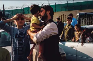  ?? Marcus Yam / TNS ?? A father with two sons en route to the Kabul internatio­nal airport, where U.S. military evacuation­s continue.