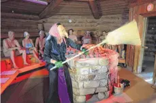  ?? FOTO: DPA ?? Aufgießeri­n Natalie Pfeiffer aus Sinsheim zeigt sich den Saunagäste­n als Hexe.