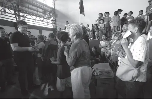  ??  ?? RODRIGO Duterte II, representi­ng his father, First District Rep. Paolo Duterte, hands over cash assistance to the fire victims of Barayco, Barangay 5-A in the barangay covered court on Saturday. BING GONZALES