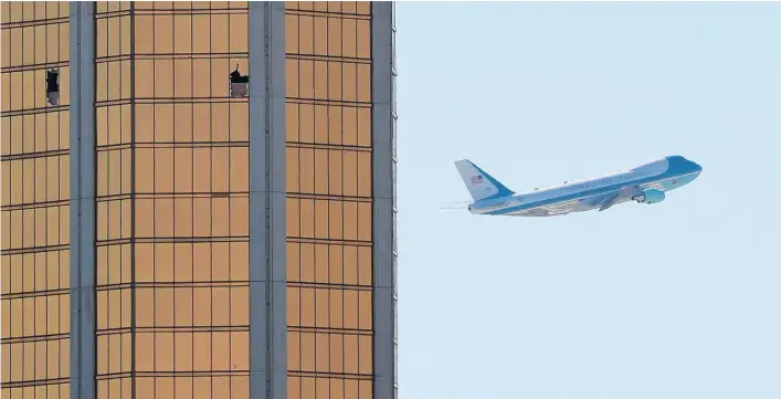  ?? Picture / Reuters ?? Air Force One, with US President Donald Trump on board, departs Las Vegas past the broken windows on the Mandalay Bay hotel from where the shooter fired.