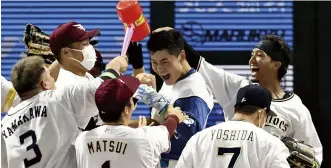  ?? The Yomiuri Shimbun ?? Kotaro Kiyomiya, center, is mobbed by Pacific League teammates after homering in the bottom of the ninth to give the PL a 3-2 win in the All-Star Game on Tuesday night in Fukuoka.