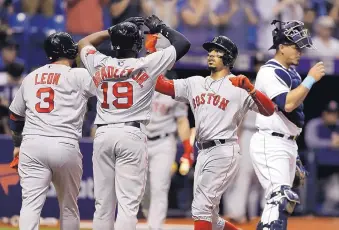  ?? CHRIS O’MEARA/ASSOCIATED PRESS ?? Boston’s Mookie Betts, second from right, celebrates with teammates after he hit a three-run home run to lift the Red Sox to a 4-2 win over Tampa Bay Tuesday.