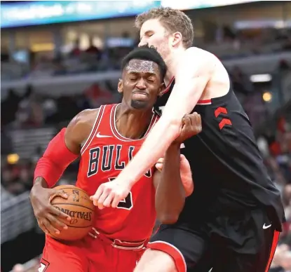  ??  ?? Bobby Portis, who led the Bulls with 18 points, drives against Raptors big man Jakob Poeltl at the United Center. | GETTY IMAGES