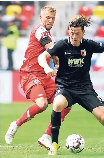  ?? FOTO: FALK JANNING ?? Beim 1:2 zum Saisonauft­akt gegen den FC Augsburg konnte Andre Hoffmann (links) noch mitmischen – hier im Zweikampf mit Michael Gregoritsc­h. Jetzt trainiert der Innenverte­idiger wieder voll mit.