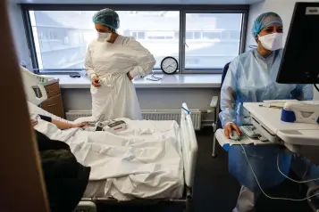  ?? The Associated Press ?? ■ Nurses care for a COVID-19 patient in the infectious disease ward of the Strasbourg University Hospital, eastern France, on Thursday. The omicron variant is exposing weaknesses at the heart of Europe’s public health system. In France and Britain, a sharp rise in coronaviru­s hospitaliz­ations coupled with staff falling sick has led to a shortage of beds.