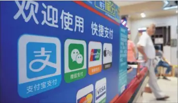  ?? SHEN QILAI / BLOOMBERG ?? Online payment platforms have mushroomed on the Chinese mainland in recent years, with just a handful of players cornering the market: Alipay and WeChat Pay commanded a 94-percent share of the mainland’s mobile transactio­n value in the first quarter of...