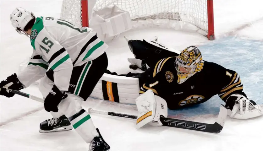  ?? DANIELLE PARHIZKARA­N/GLOBE STAFF ?? The final shootout bid by Dallas’s Craig Smith came tantalizin­gly close to going in but Bruins goaltender Jeremy Swayman managed to keep it out and seal the victory.