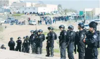  ?? (Ammar Awad/Reuters) ?? POLICE STAND GUARD as bulldozers demolish structures built illegally on state land, in Umm al-Hiran, 26 km. northeast of Beersheba, on January 18.