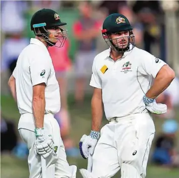  ??  ?? Hunting in pairs Australia batsmen Shaun Marsh (right) and Adam Voges chat during their unbroken 317-run partnershi­p on the first day of the first Test against the West Indies yesterday.