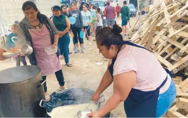  ?? ELLIOT SPAGAT/AP ?? A woman ladles rice and beans for a line of migrants last week at a shelter in Tijuana, Mexico.