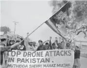  ?? S. MIRZA/AFP/GETTY IMAGES FILES ?? A Pakistani demonstrat­or holds a burning U.S. flag during a protest in Multan against killer-drone attacks in Pakistan’s tribal areas last month.