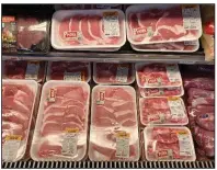  ?? (AP/Matt Rourke) ?? Cuts of pork fill a case at a grocery store in Roslyn, Pa., on Tuesday. Wholesale prices, boosted by rising food costs, increased 0.8% in May, and have climbed by a record amount over the past year.