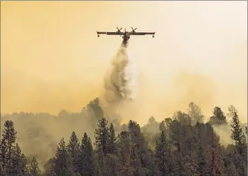  ?? Photograph­s by Andrew Seng The Sacramento Bee ?? WATER IS dropped onto a hillside with dense growth near Mokelumne Hill on Friday. More than 2,400 firefighte­rs were battling the blaze, which briefly forced the evacuation of about 2,700 people.