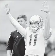  ??  ?? QUARTERBAC­K Jerry Neuheisel signals a touchdown during UCLA’s spring football game.