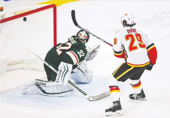  ?? HARRISON BARDEN/USA TODAY SPORTS ?? Flames centre Dillon Dube roofs the winning goal over Minnesota goalie Alex Stalock during Sunday’s shootout at Xcel Energy Center in St. Paul.